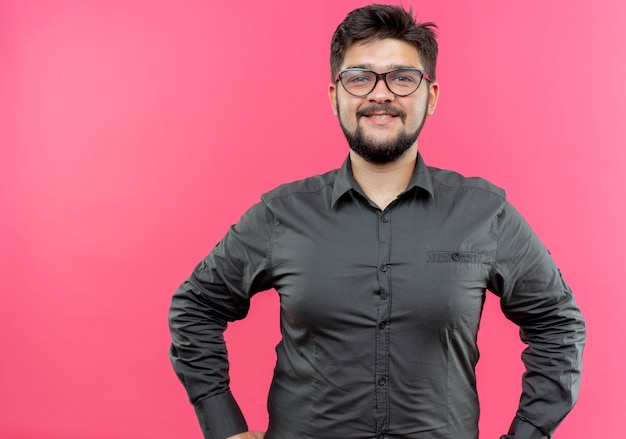 Foto gratuita feliz joven empresario con gafas aislado sobre fondo de color rosa