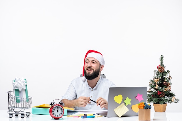 Feliz joven empresario positivo con sombrero de santa claus trabajando solo