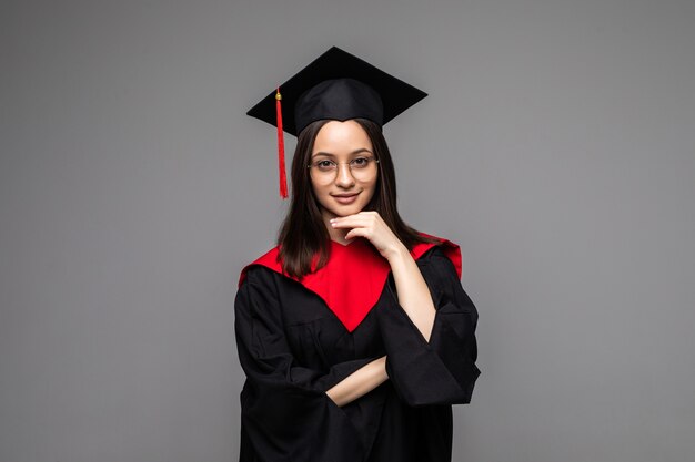 Feliz joven estudiante con diploma en gris