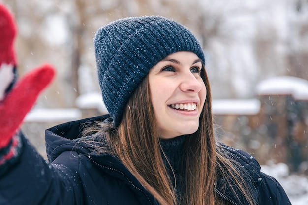 Feliz joven en guantes rojos con la bandera de canadá en tiempo de nieve