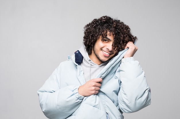 Feliz joven juguetona sonrisa aislada en la pared blanca