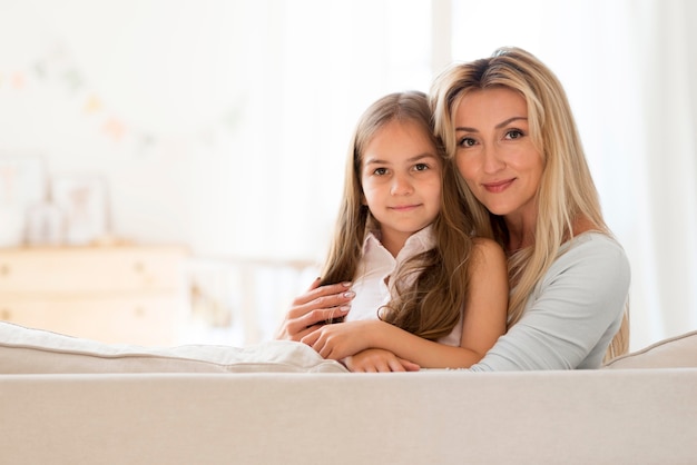 Feliz joven madre e hija posando juntos