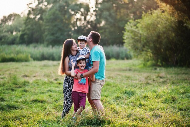 Feliz joven madre de familia padre dos hijos hijo en la naturaleza divirtiéndose