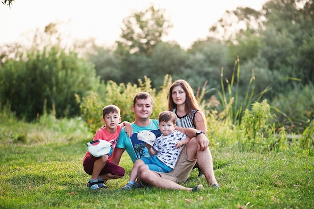 Feliz joven madre de familia padre dos hijos hijo en la naturaleza divirtiéndose