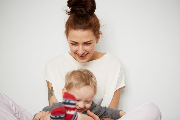 Feliz joven madre con hijo pequeño en casa