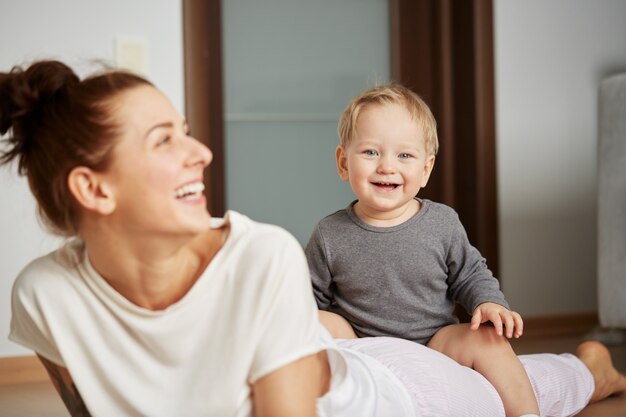 Feliz joven madre con hijo pequeño en casa