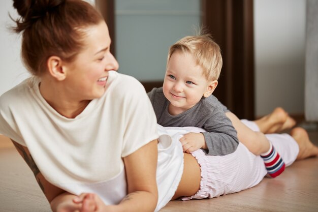 Feliz joven madre con hijo pequeño en casa