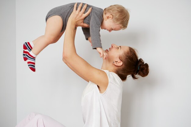 Feliz joven madre con hijo pequeño en casa