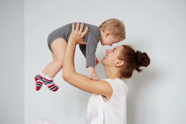 Feliz joven madre con hijo pequeño en casa