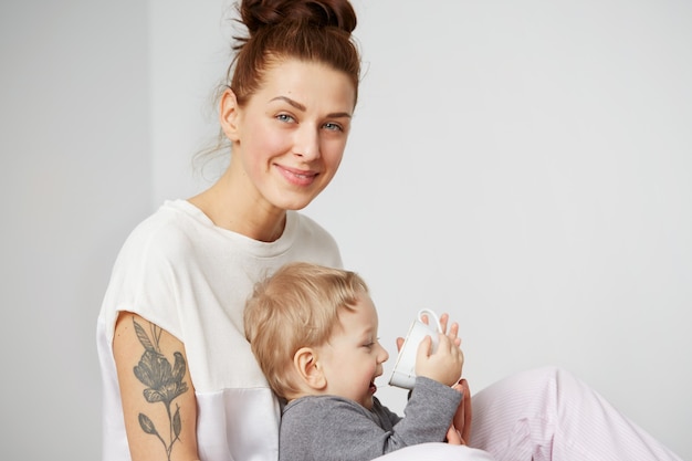 Feliz joven madre con hijo pequeño en casa