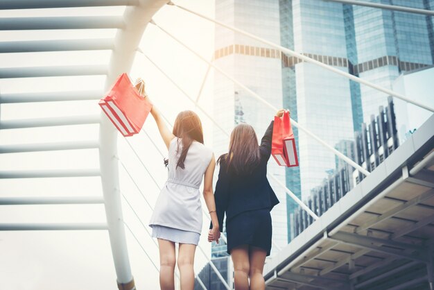 Feliz joven mujer de negocios la celebración de bolsas de la compra.