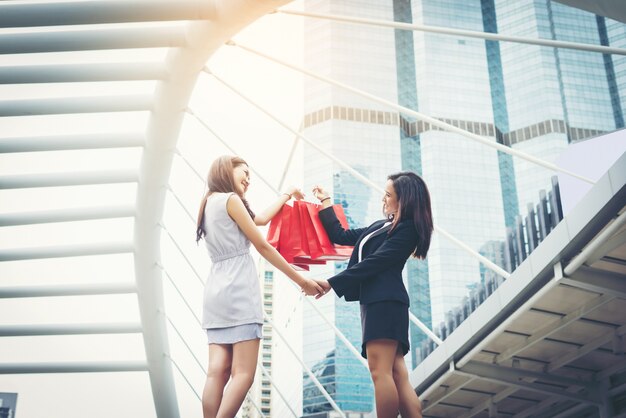 Feliz joven mujer de negocios la celebración de bolsas de la compra.