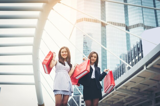 Feliz joven mujer de negocios la celebración de bolsas de la compra.