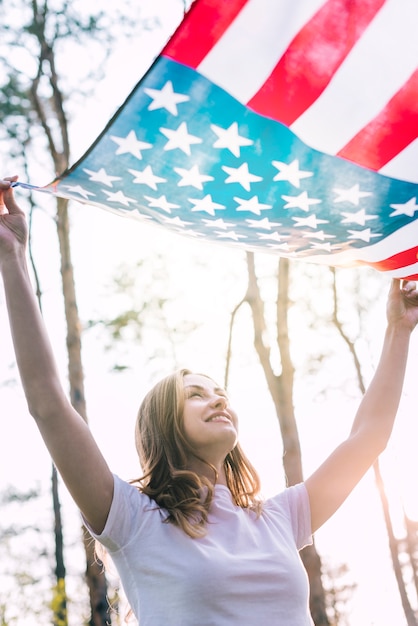 Foto gratuita feliz joven mujer ondeando bandera de estados unidos