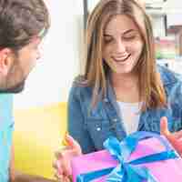 Foto gratuita feliz joven recibiendo el regalo de su marido