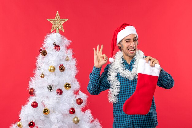 Feliz joven con sombrero de santa claus en una camisa azul a rayas