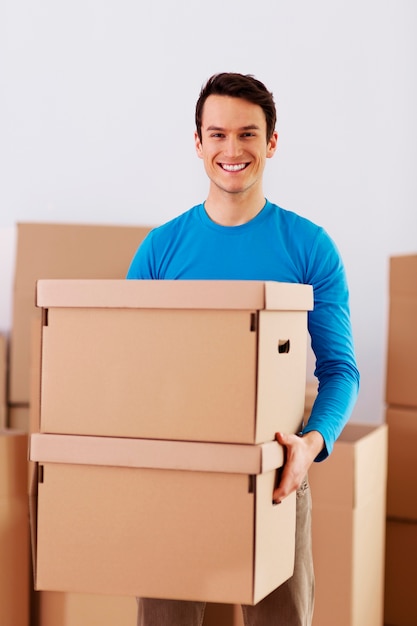 Feliz joven sosteniendo cajas de cartón