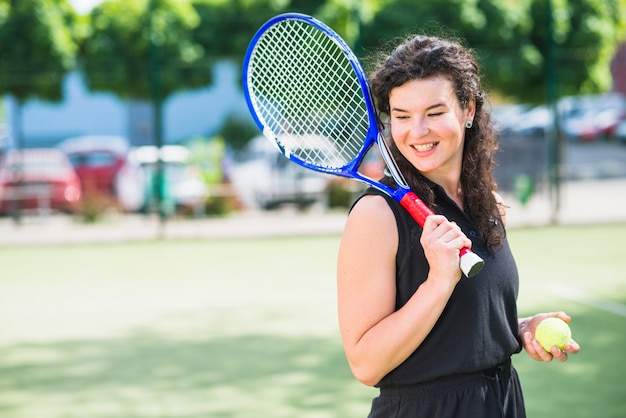 Foto gratuita feliz jugadora de tenis en la cancha