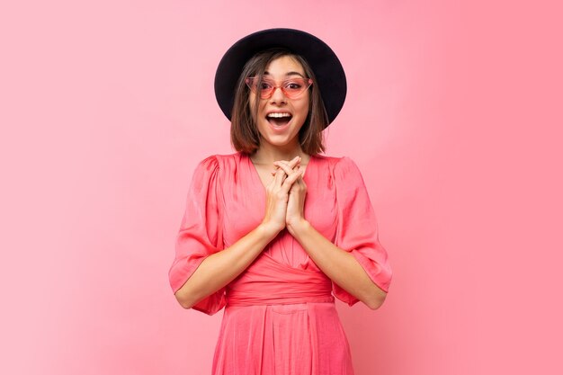 Feliz linda chica en vestido rosa posando