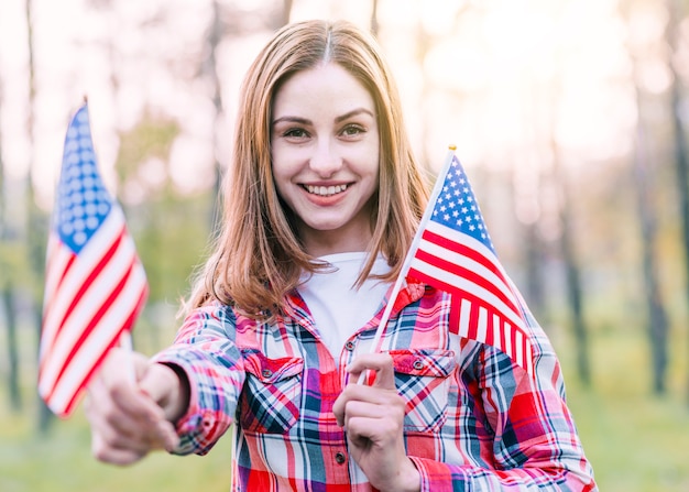 Foto gratuita feliz linda mujer joven con banderas americanas
