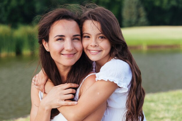 Feliz madre e hija abrazando al aire libre retrato