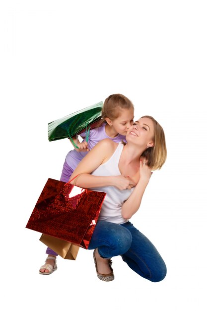 Feliz madre e hija con bolsas de compras