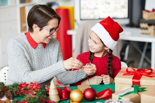 Feliz madre e hija envolver regalos de Navidad