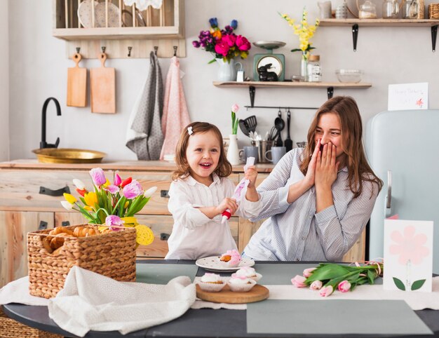 Feliz madre e hija haciendo cupcake