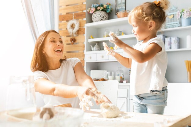 Feliz madre e hija preparando masa