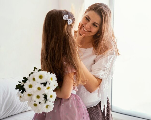 Feliz madre e hija con ramo de flores de primavera