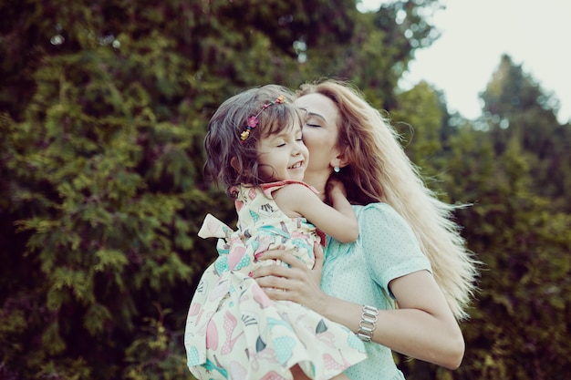 Foto gratuita feliz madre e hija riendo juntos al aire libre