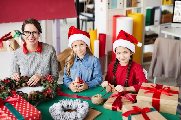 Feliz madre e hijas con regalos de Navidad