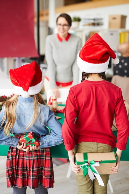 Feliz madre e hijos intercambiando regalos de Navidad