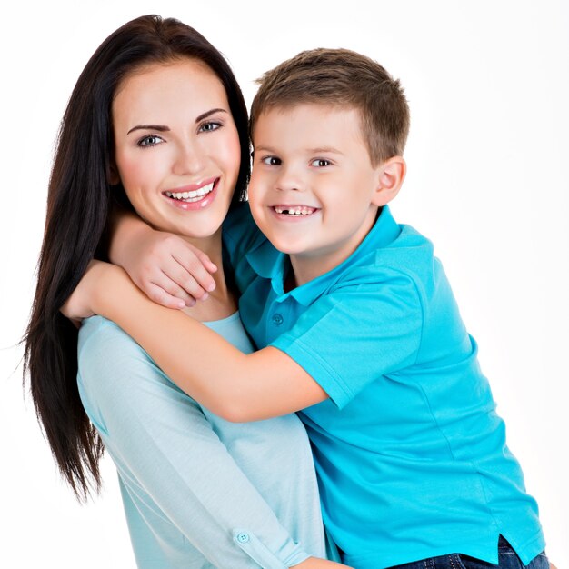 Feliz madre joven sonriente con hijo. Aislado en blanco