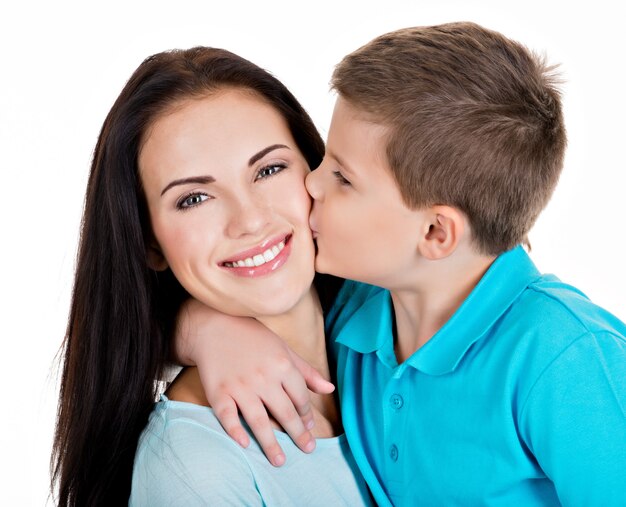 Feliz madre joven sonriente con hijo. Aislado en blanco