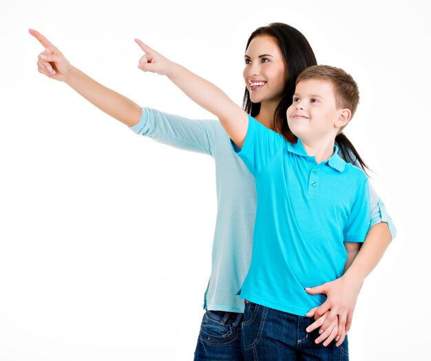 Foto gratuita feliz madre joven sonriente con hijo apuntando con los dedos. aislado en blanco