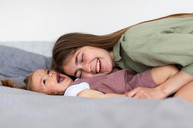 Feliz madre y niña en la cama