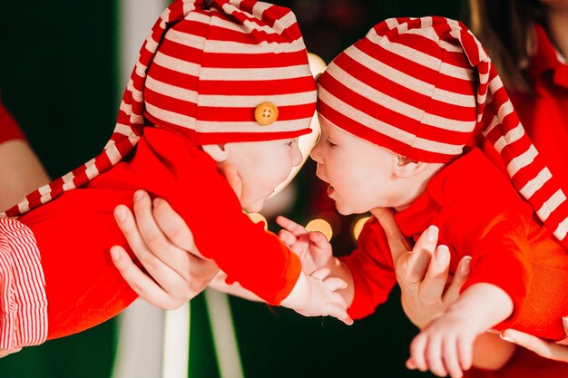 Feliz mamá y papá posan con graciosos gemelos en sus brazos