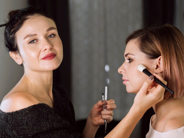 Feliz maquilladora profesional trabajando