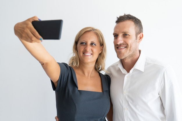 Feliz mediados mujer adulta tomando selfie con su marido a través del teléfono.
