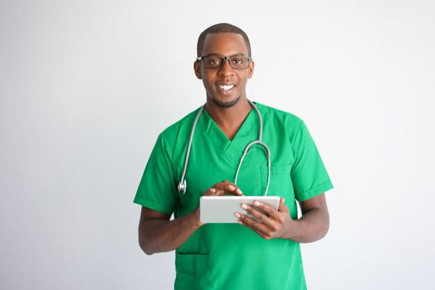 Feliz médico masculino negro con tablet PC. Tecnología en concepto de la medicina.