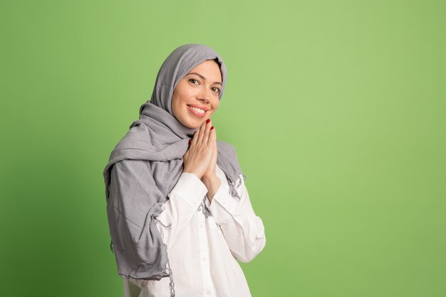 Feliz mujer árabe en hijab. Retrato de niña sonriente, posando en el estudio verde.