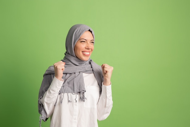 Feliz mujer árabe en hijab. Retrato de niña sonriente, posando en el estudio verde.