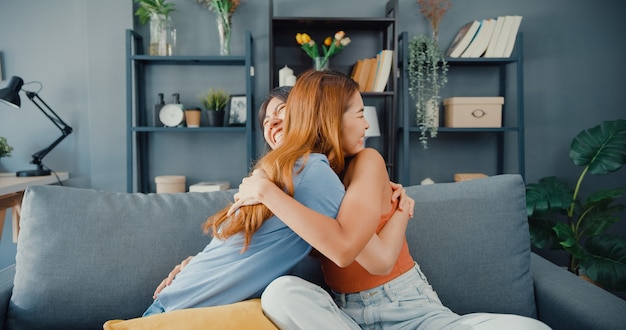 Feliz mujer asiática adolescente visita a sus amigos cercanos abrazos sonriendo en casa