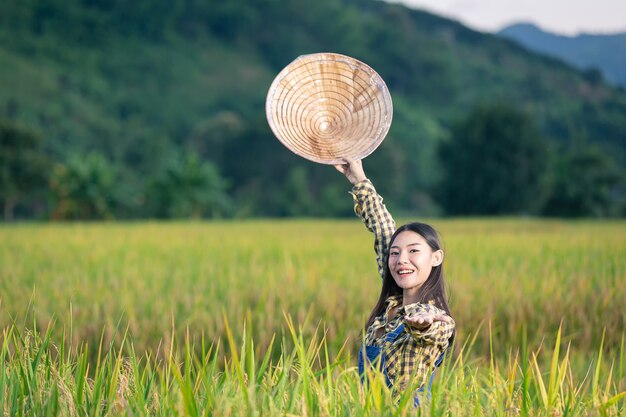 Feliz mujer asiática escribir notas en campos de arroz