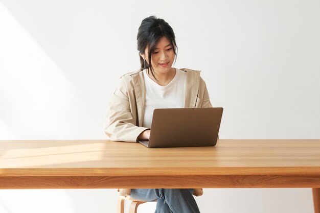 Feliz mujer asiática trabajando desde casa