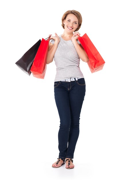 Feliz mujer blanca con bolsas de la compra en blanco