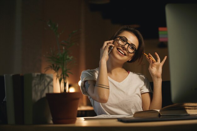 Feliz mujer diseñadora hablando por teléfono móvil