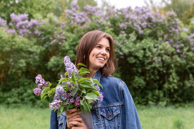 Foto gratuita feliz mujer con flores lilas