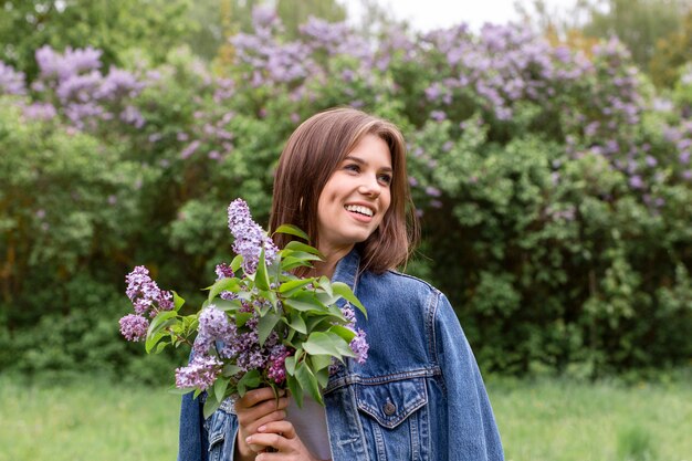 Feliz mujer con flores lilas